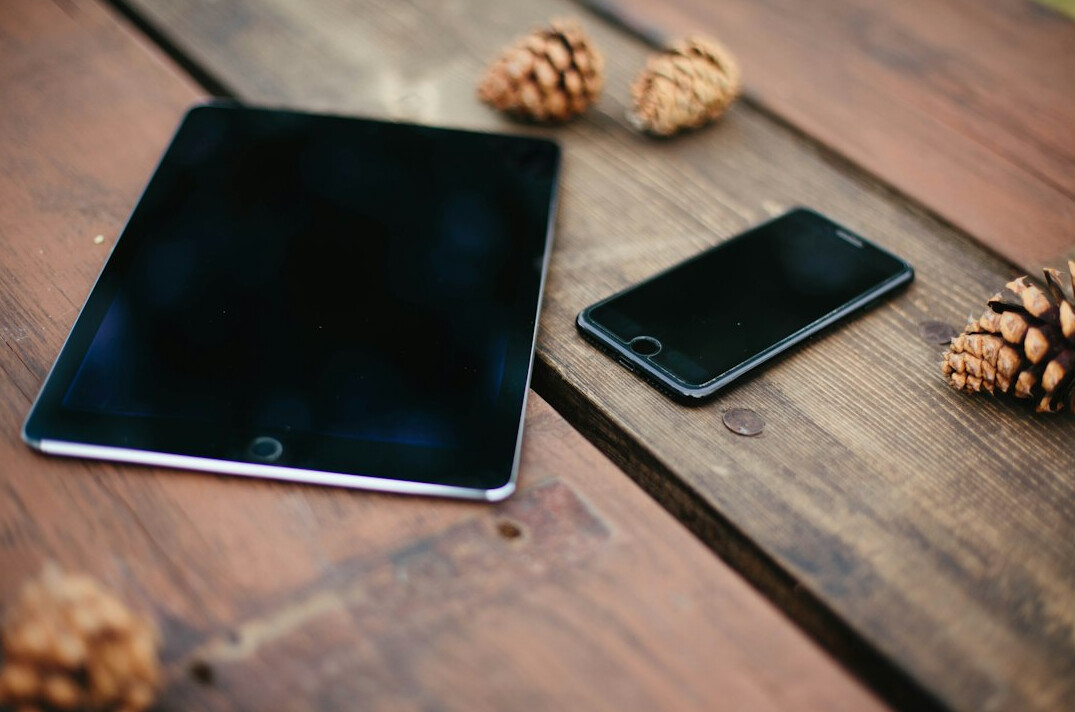 Smartphone and tablet showing longitudinal data trend lines on a table