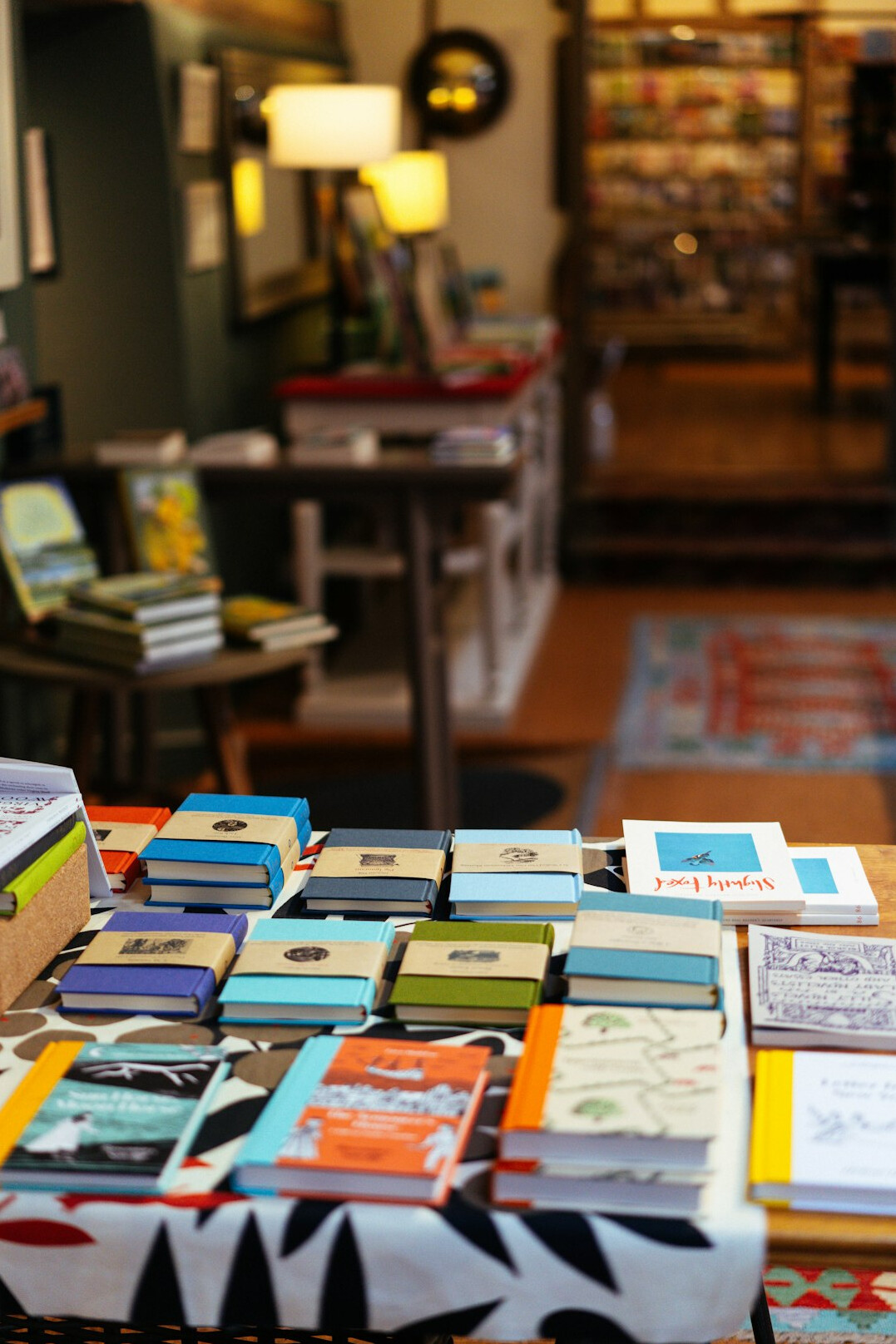 Stacks of magazines and printed media with colored sticky notes on a table